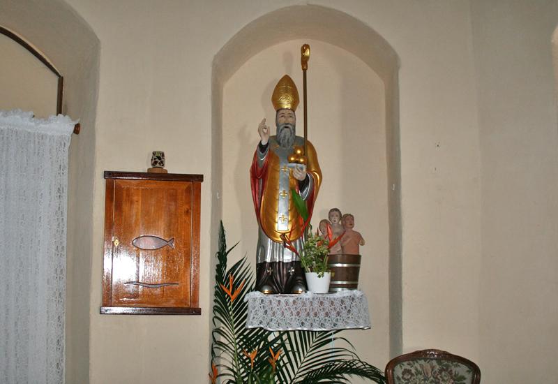 Saint Nicholas, in polychrome stucco, with three children at his feet